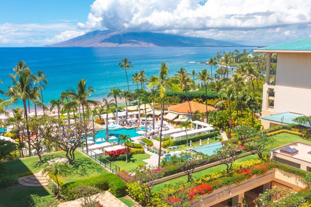 Aerial view of Four Seasons pool with coastline and mountain in the background.